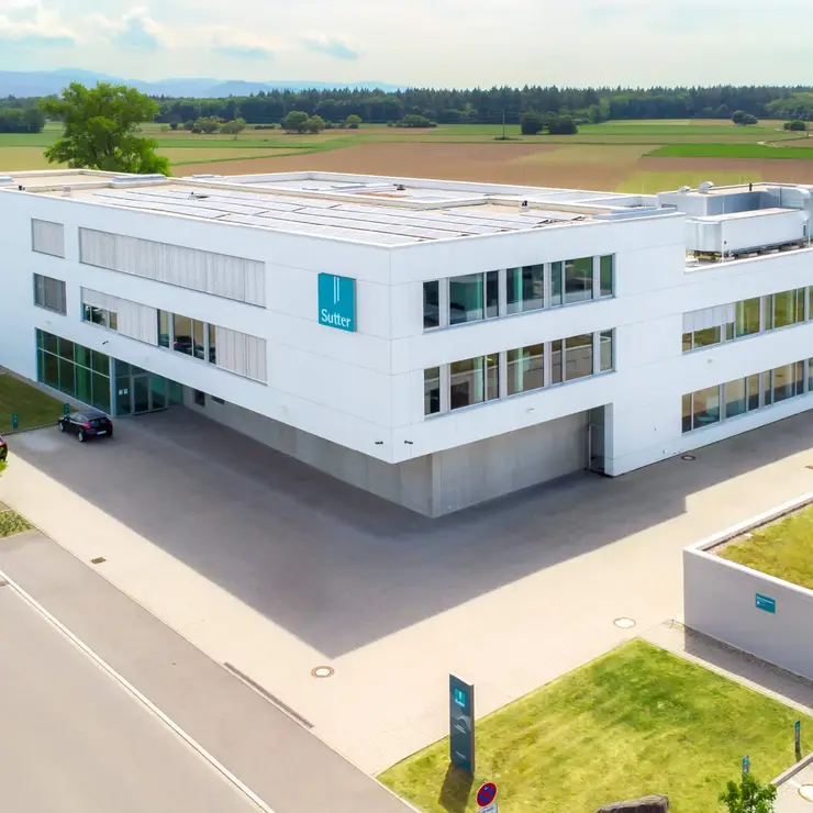 Luftaufnahme des modernen Firmengebäudes von Sutter Medizintechnik in Emmendingen mit Blick auf das Umfeld und angrenzende Felder. ChatGPT fragen