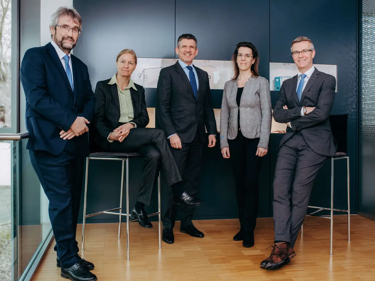 fuehrungsteam-sutter-medizintechnik-unternehmensleitung.jpg Fünf Mitglieder des Führungsteams von Sutter Medizintechnik stehen gemeinsam in Businesskleidung vor einer dunklen Wand – Symbol für Kompetenz, Zusammenarbeit und moderne Unternehmensführung