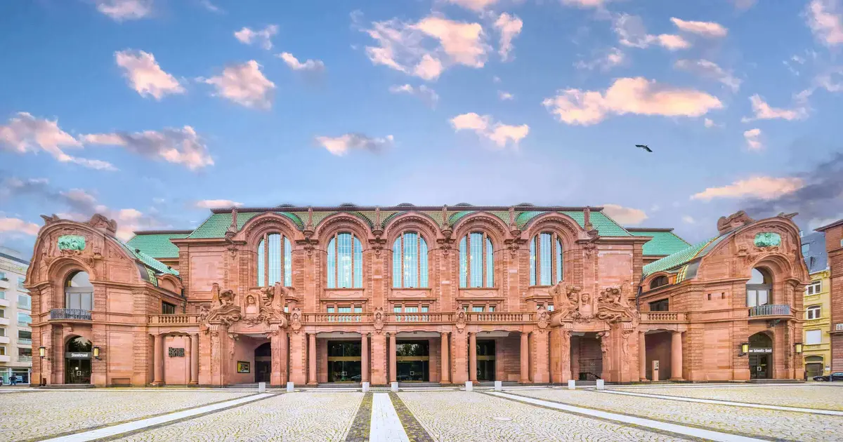 Mannheim-Nationaltheater-Fassade-Abendstimmung.jpg Frontansicht des Nationaltheaters Mannheim mit eindrucksvoller historischer Sandsteinfassade unter einem malerischen Abendhimmel.