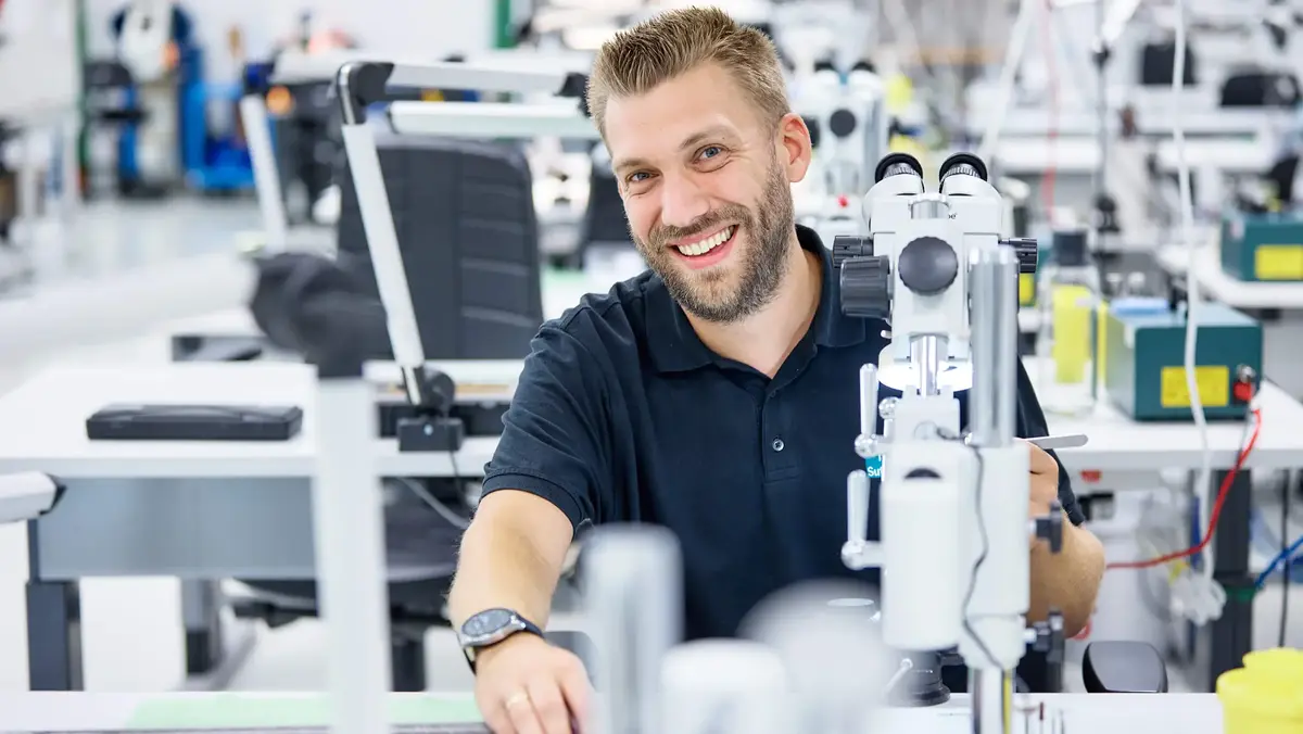 © Jörg Wilhelm Porträt eines lächelnden Mitarbeiters bei Sutter Medizintechnik in der Produktion – Engagement und Präzisionsarbeit in der Medizintechnikfertigung.