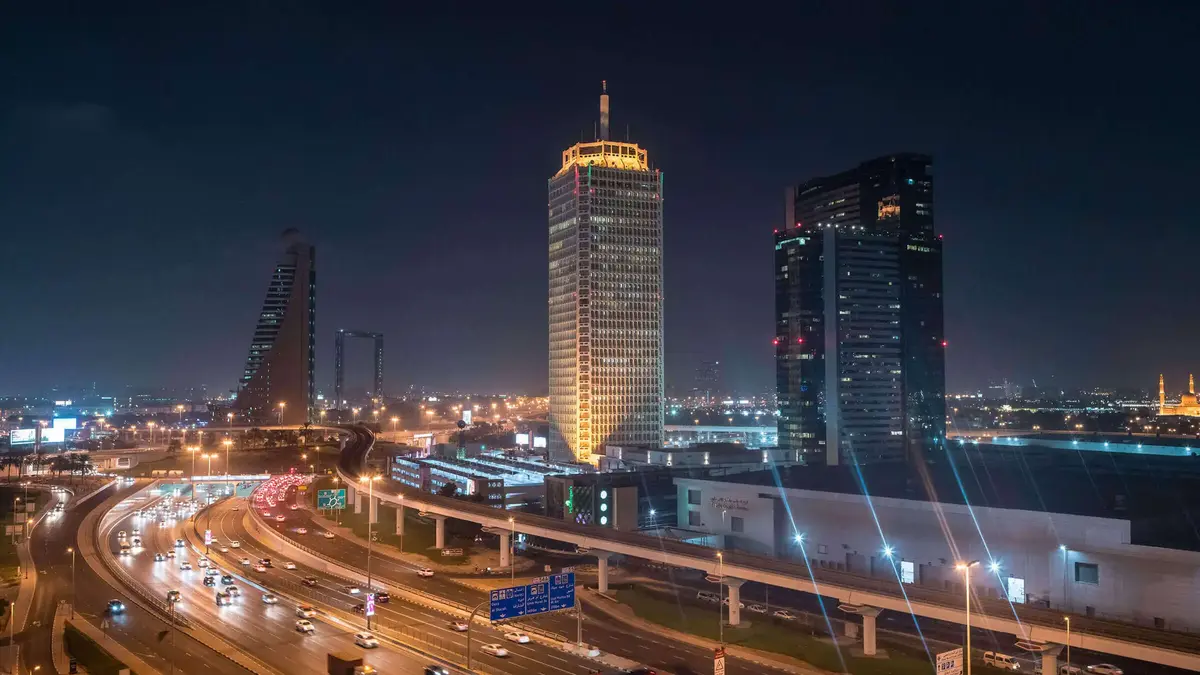 Dubai-Sheikh-Zayed-Road-Skyline-Nacht.jpg Nächtlicher Blick auf die Skyline von Dubai mit beleuchteten Hochhäusern und der Sheikh Zayed Road – modernes Stadtbild mit Verkehr und Architektur.