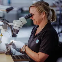 Feinmechanikerin bei der Arbeit am Mikroskop in der Produktion bei Sutter Medizintechnik