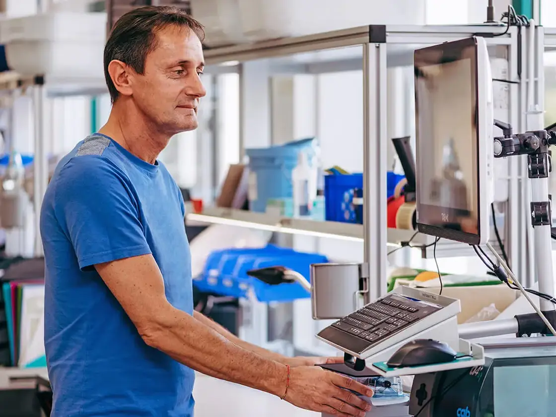 sutter-produktion-mitarbeiter-an-maschine.jpg Ein Mitarbeiter von Sutter Medizintechnik bedient eine Fertigungsmaschine in der Produktion – Fokus auf Präzision und Effizienz