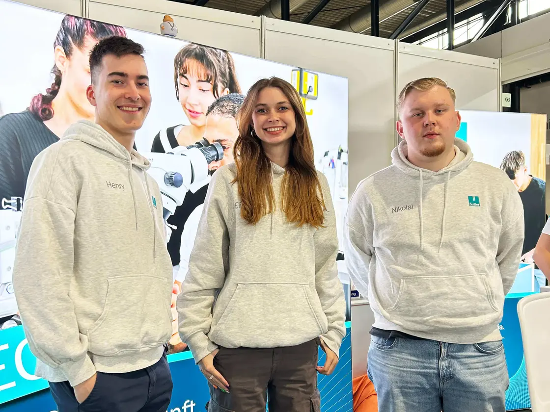 Sutter-Medizintechnik-Team-Nachwuchsmesse.jpg Drei junge Auszubildende von Sutter Medizintechnik lächeln am Messestand in die Kamera.