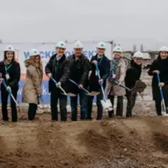 spatenstich-sutter-medizintechnik-emmendingen-team.jpg Acht Personen mit weißen Sutter-Bauhelmen und Spaten stehen auf der Baustelle beim offiziellen Spatenstich für das neue Gebäude in Emmendingen.