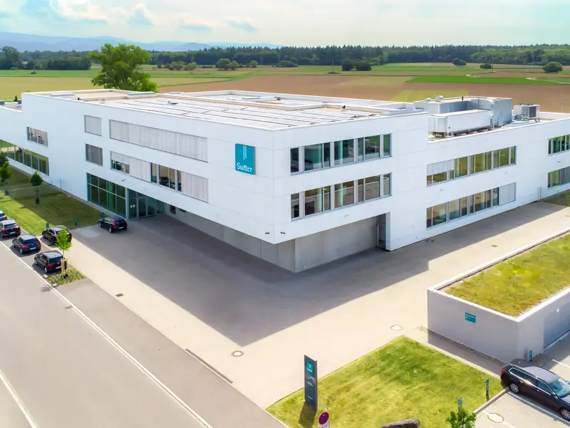 Luftaufnahme des modernen Firmengebäudes von Sutter Medizintechnik in Emmendingen mit Blick auf das Umfeld und angrenzende Felder. ChatGPT fragen