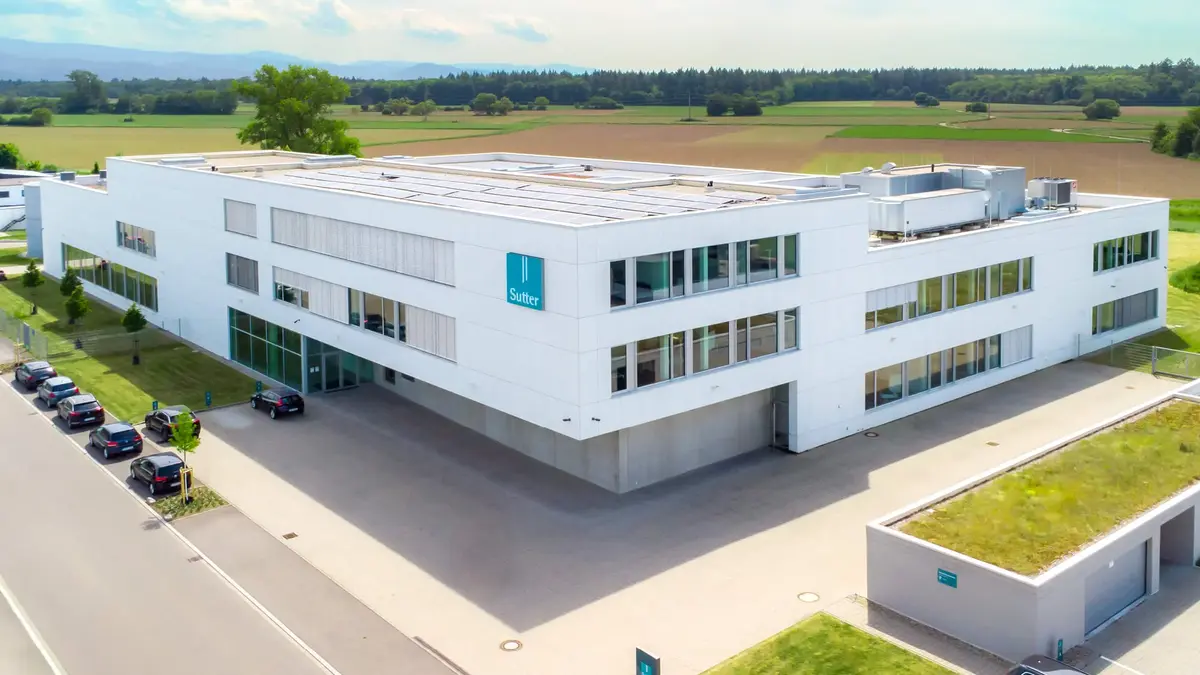 Luftaufnahme des modernen Firmengebäudes von Sutter Medizintechnik in Emmendingen mit Blick auf das Umfeld und angrenzende Felder.        ChatGPT fragen