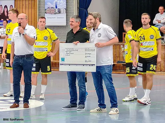 Sutter-Spendenuebergabe-SpoFunnis-2024.jpg Bert Sutter übergibt symbolischen Spendenscheck an SpoFunnis bei einem Handball-Heimspiel – Engagement für Kinder- und Jugendarbeit in der Region.