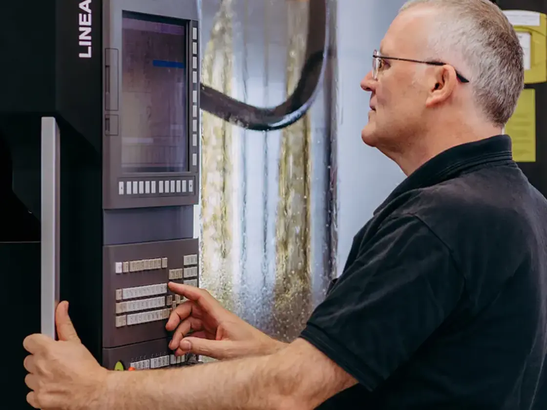 sutter-cnc-fertigung-mitarbeiter-an-maschine.jpg Erfahrener Mitarbeiter von Sutter Medizintechnik bedient eine CNC-Fräsmaschine zur Herstellung chirurgischer Instrumente